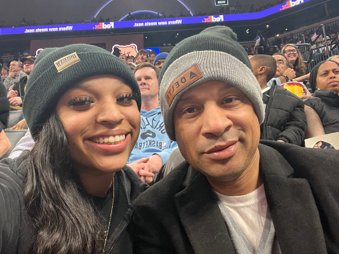 Cory Henderson and his daughter wearing beanies at the FedExForum during a Memphis Grizzlies game, smiling together