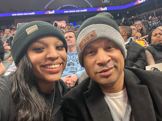 Cory Henderson and his daughter wearing beanies at the FedExForum during a Memphis Grizzlies game, smiling together