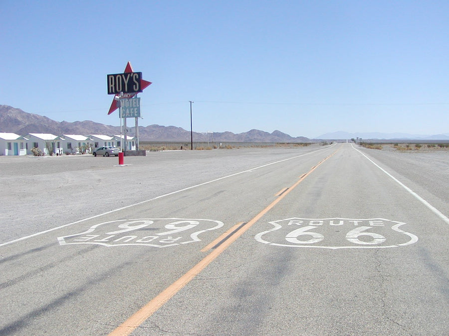 Historic Route 66 road emblems and Roy’s roadside sign along the highway in Amboy California
