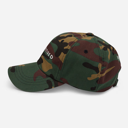 Camo embroidered I’m Retired travel dad hat from Retired Traveler (Left side)