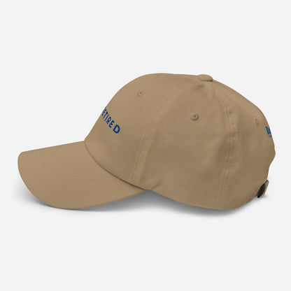 Khaki I’m Retired travel dad hat with royal blue embroidery from Retired Traveler (Left)